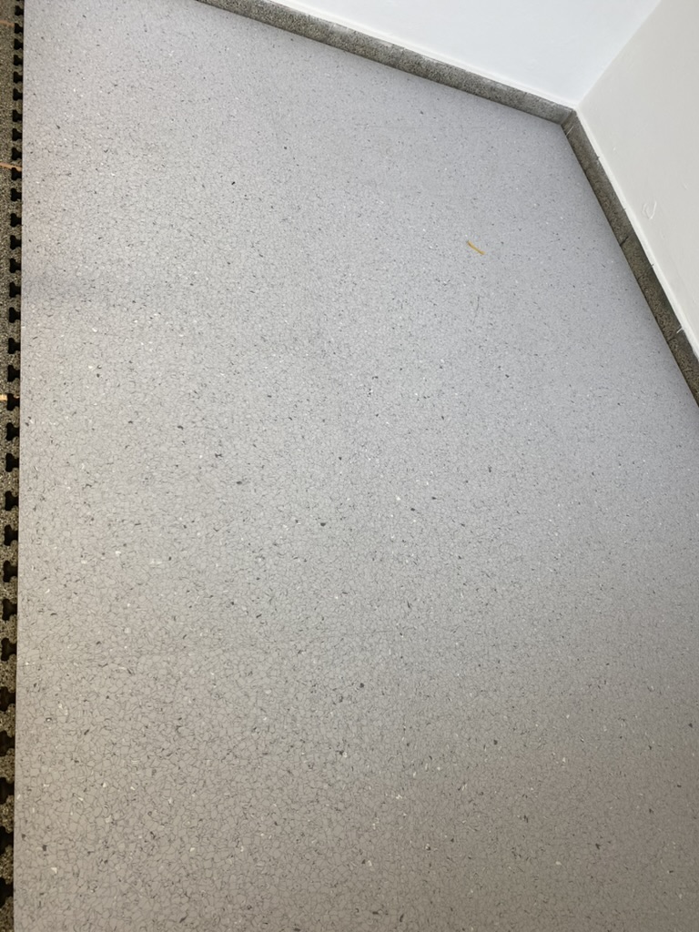Detail einer hellgrauen lose verlegten Industriebodenplatte